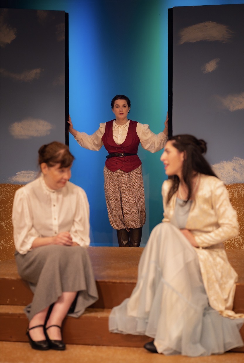 Period costume scene with painted sky backdrop