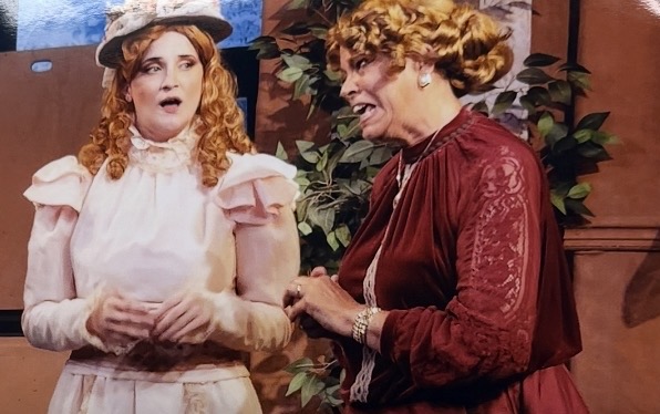 Period scene with two women in Victorian costume mid-dialogue