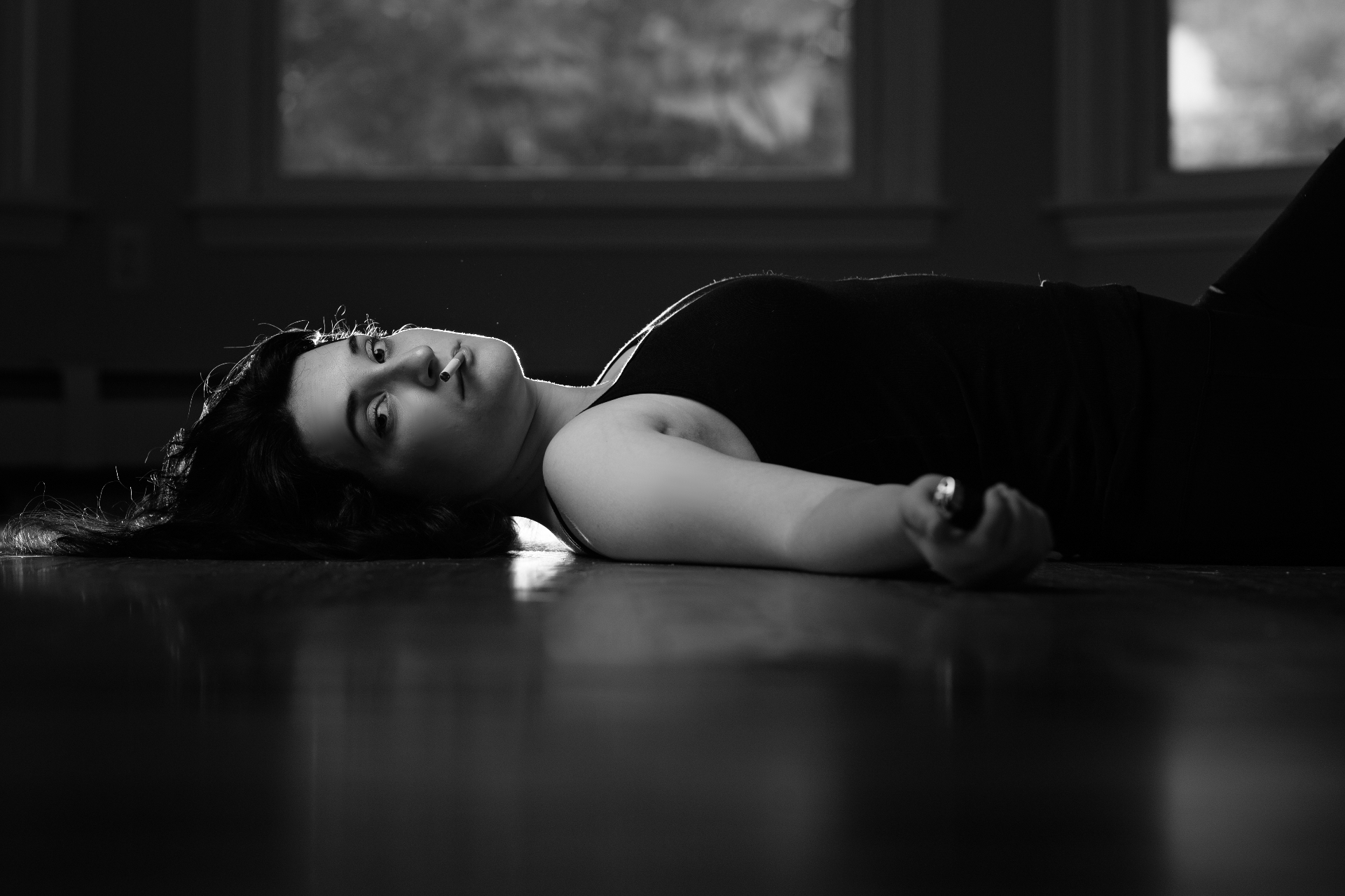 Dramatic black and white scene, actor lying on reflective stage floor
